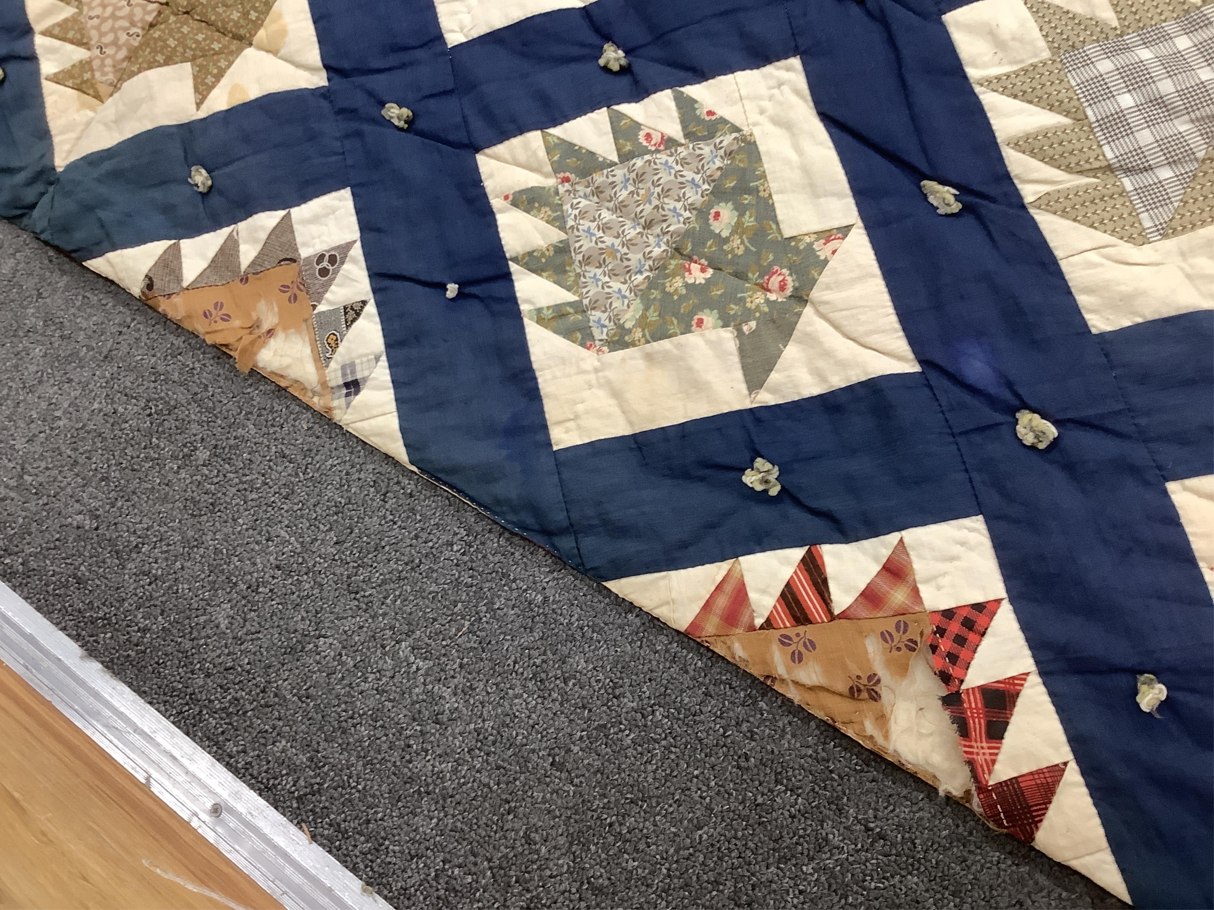 A bold handsome, American, Vermont 1865 (Civil War) ‘basket’ and lattice, hand quilted and piece tied bedcover, with an ornate floral backing. Worked with a plain navy cotton lattice border around central stylised printe